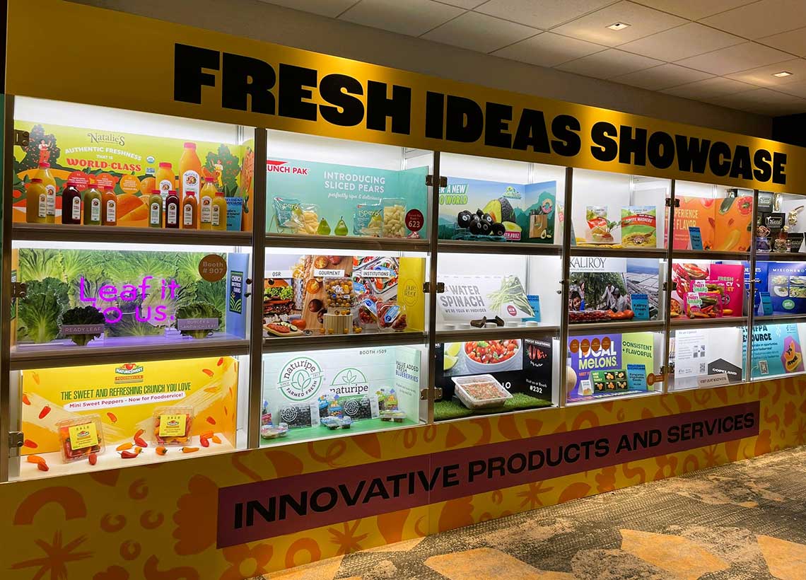 Display case labeled "FRESH IDEAS SHOWCASE" with various food products and promotional materials. Display case labeled "FRESH IDEAS SHOWCASE" with various food products and promotional materials.
